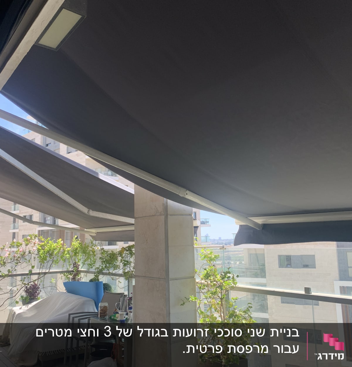 סוככים כהים על מרפסת עם צמחייה מסביב
